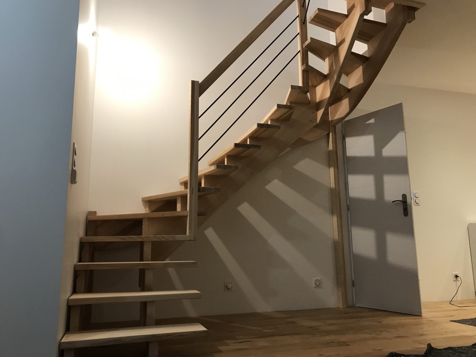 Escalier sur crémaillères déportées à double quart tournant et marches balancées