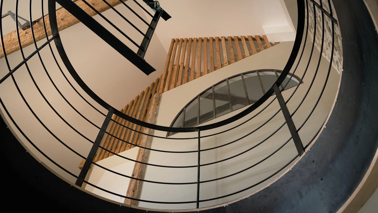 Escalier hélicoïdal monumental en frêne massif et acier sur limons débillardés